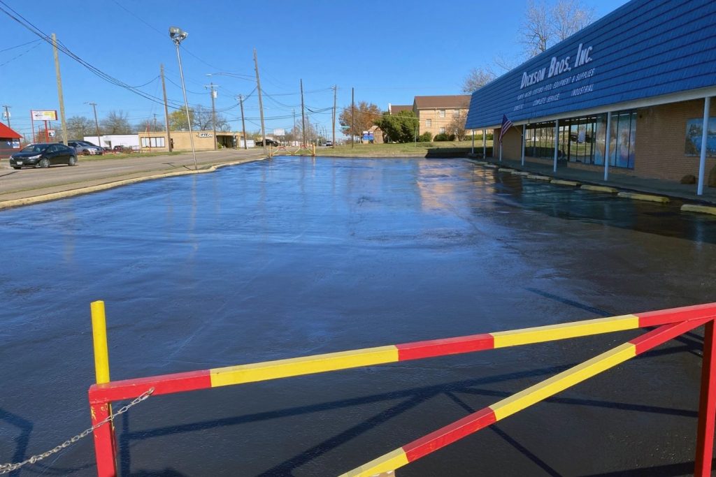 Asphalt Overlay in Fort Worth TX, features expert services, higlighted by a parking lot with a yellow and red barrier